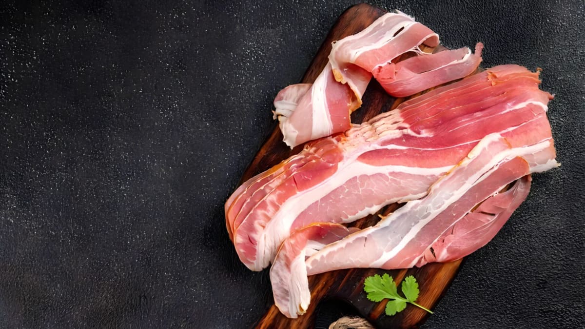 Raw bacon on a black background.