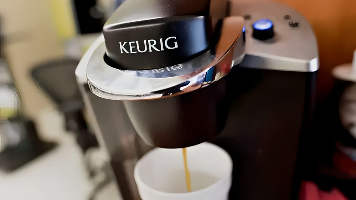 A Keurig coffee maker brewing coffee.