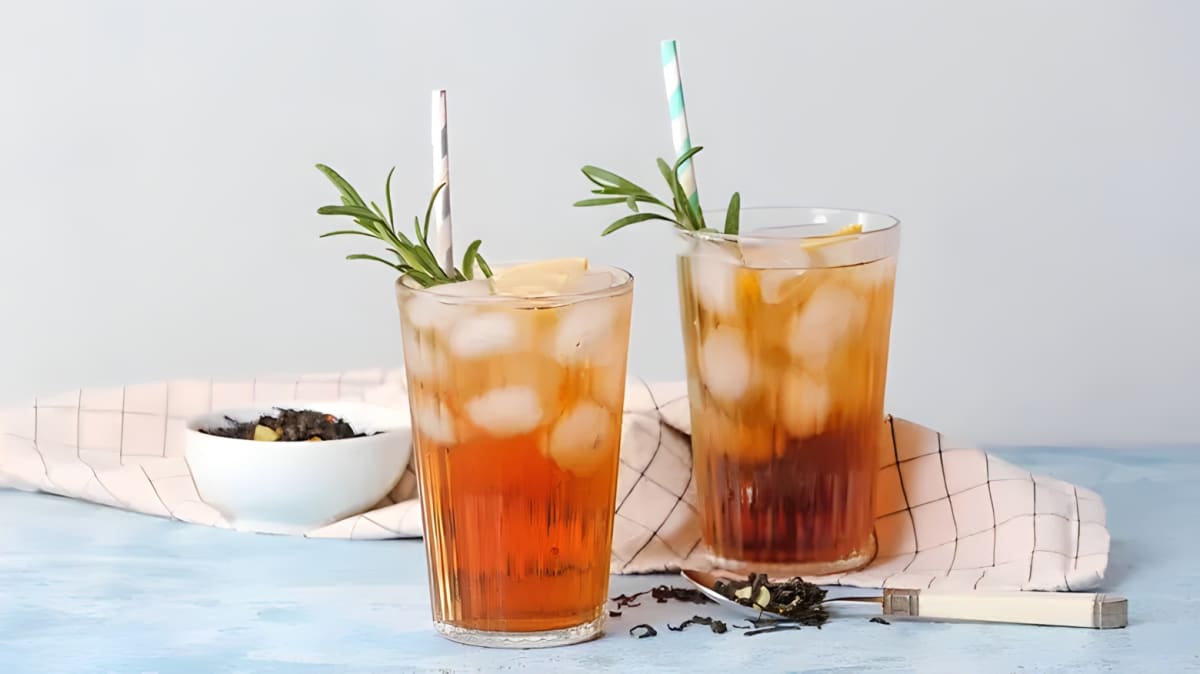 Two glasses of iced tea with straws.