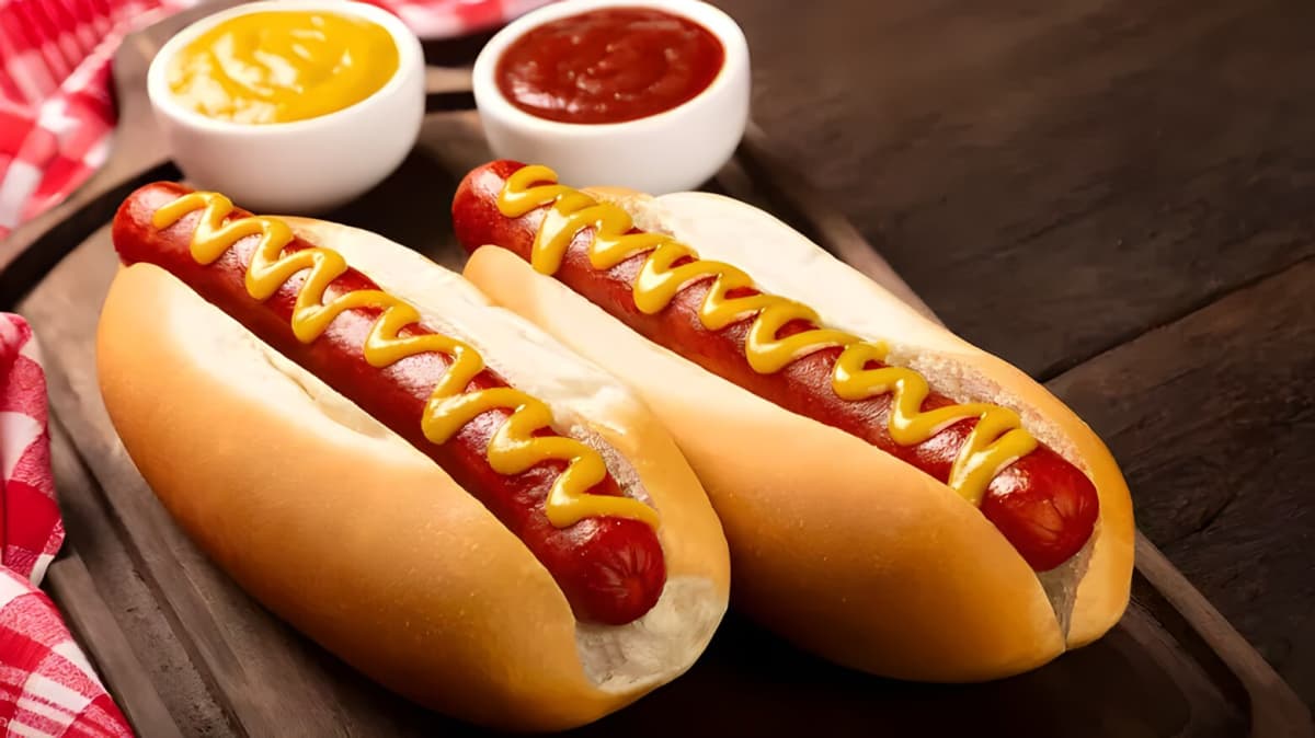 Two hot dogs with mustard.
