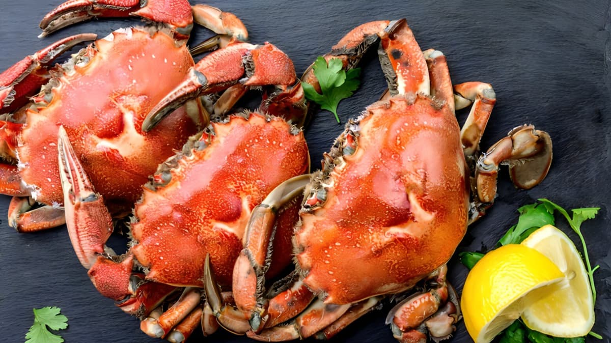 Whole crab with lemon wedges.