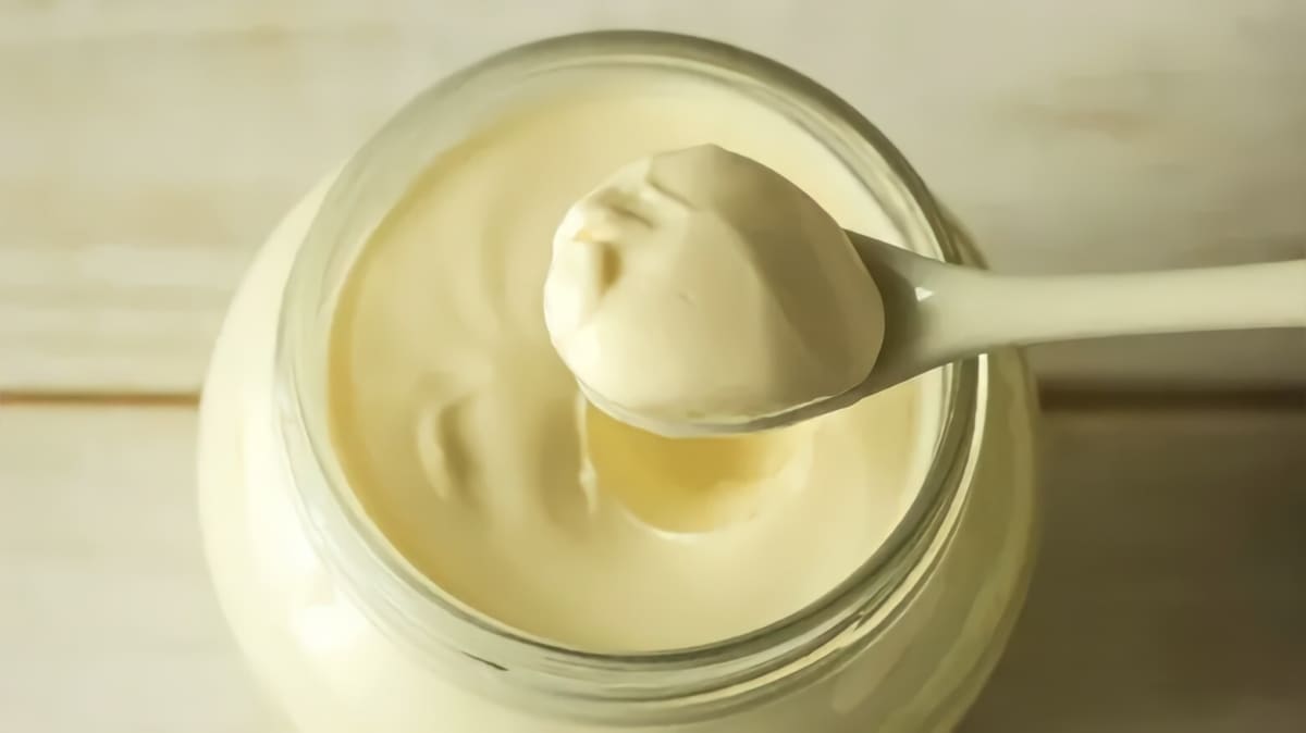 Spooning mayonnaise from a jar.