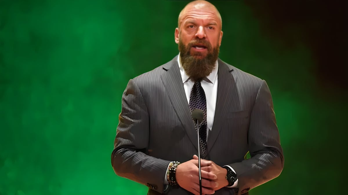 Triple H wearing suit speaking into the microphone