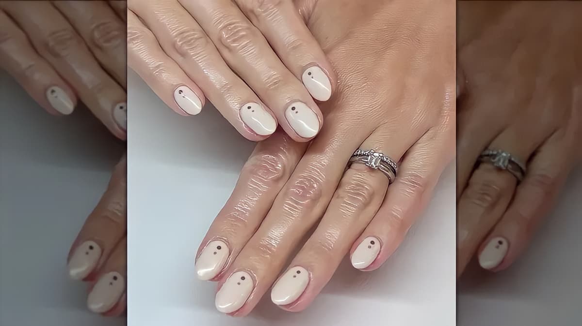 Cream nails with dotted nail art.